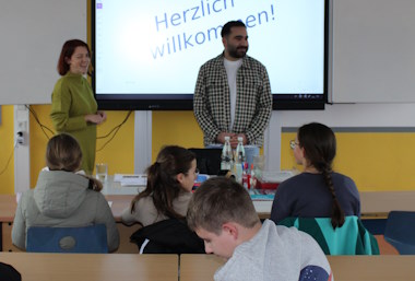 Die Ausbilder Evelyn Winkler und Felsun Aslan stellen den Schülerinnen und Schülern die Firma FeBA vor.